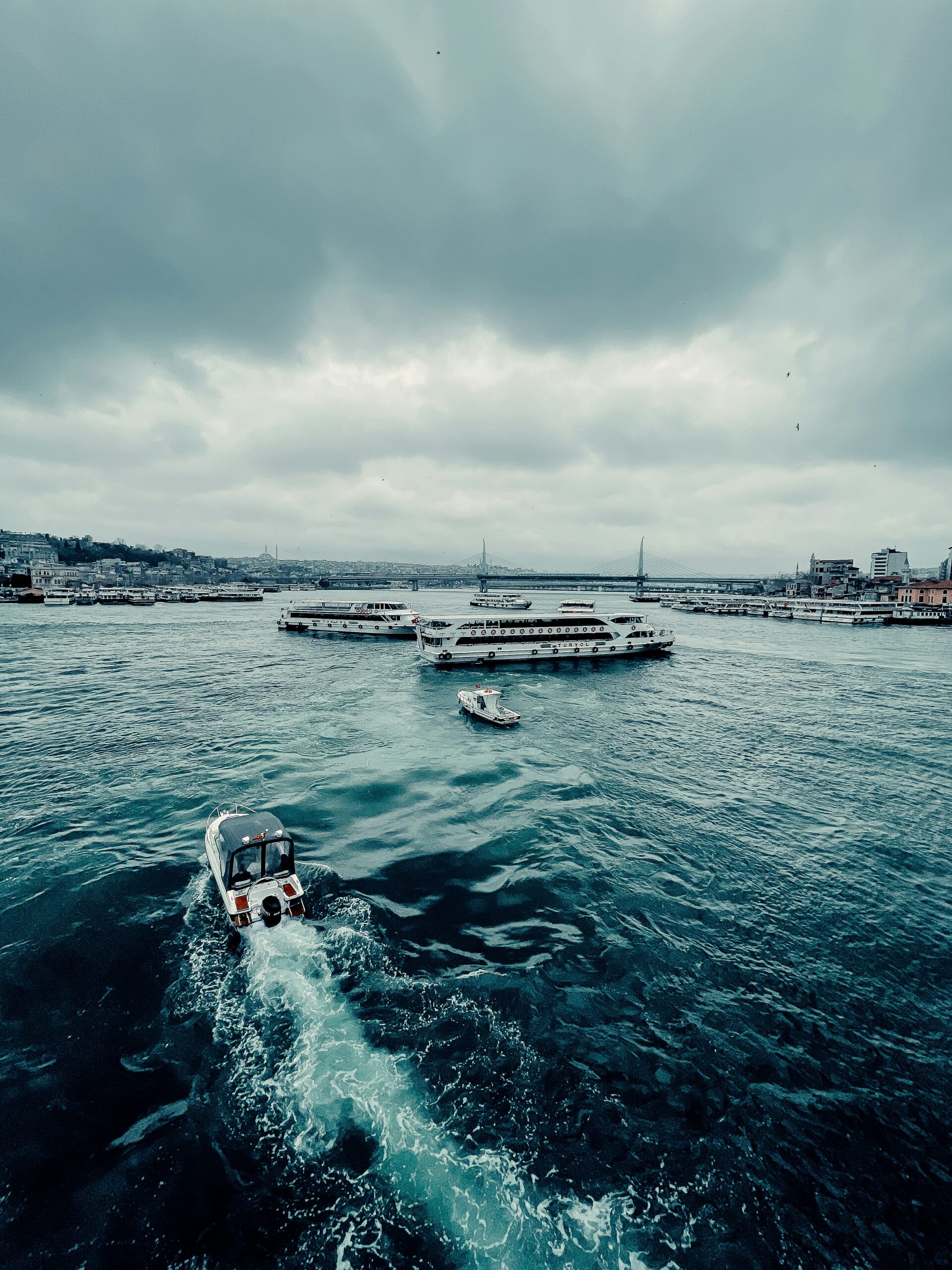 white and black boat on sea under white clouds during daytime