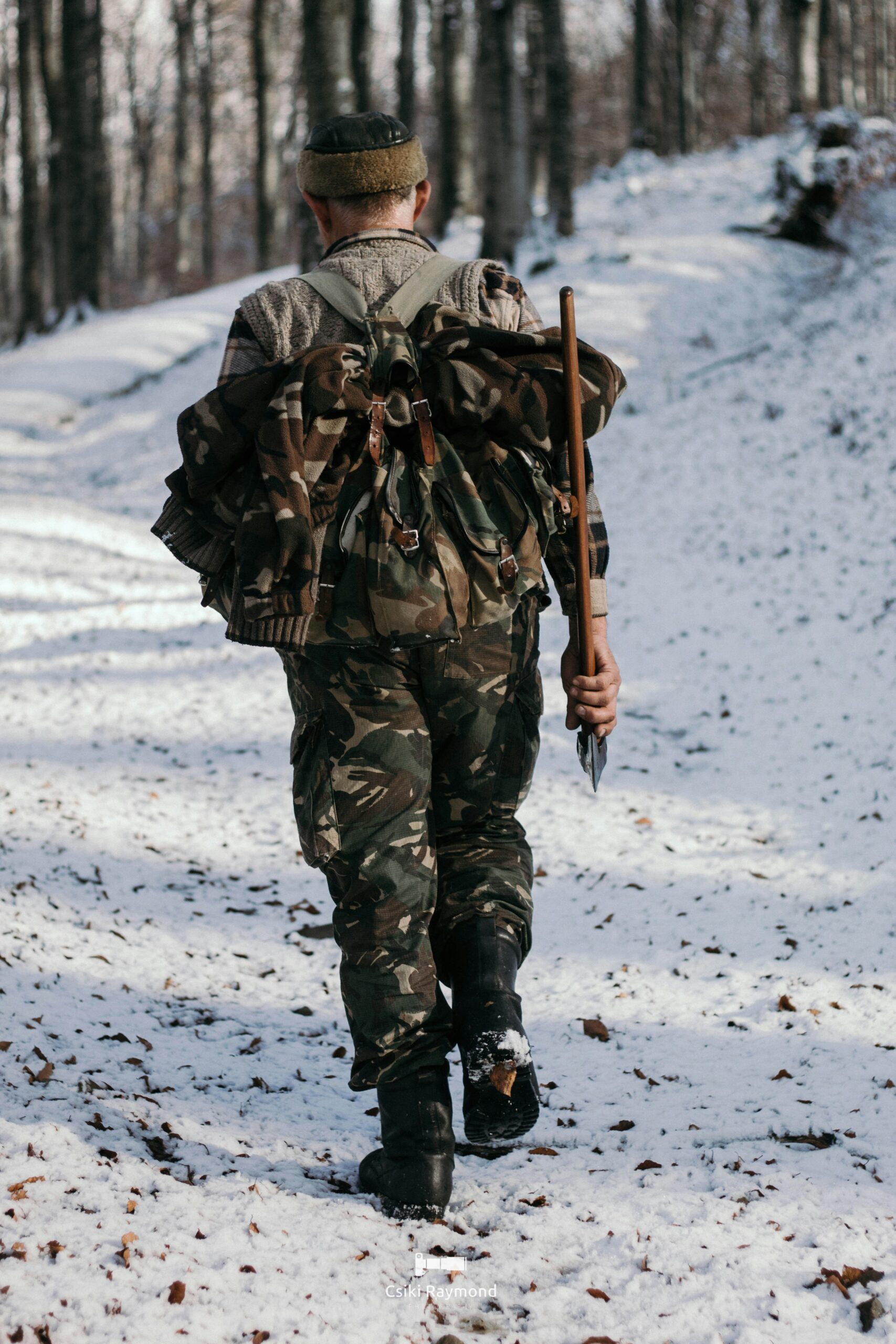 a man in camouflage walking in the snow